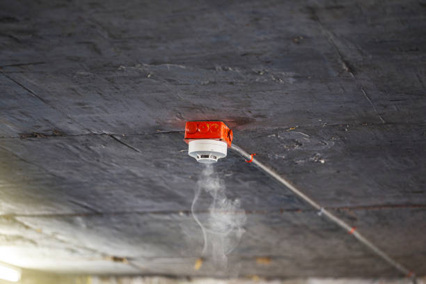 Smoke detector on precast concrete ceiling. Close up of smoke detector for fire protection systems. Selective focus.